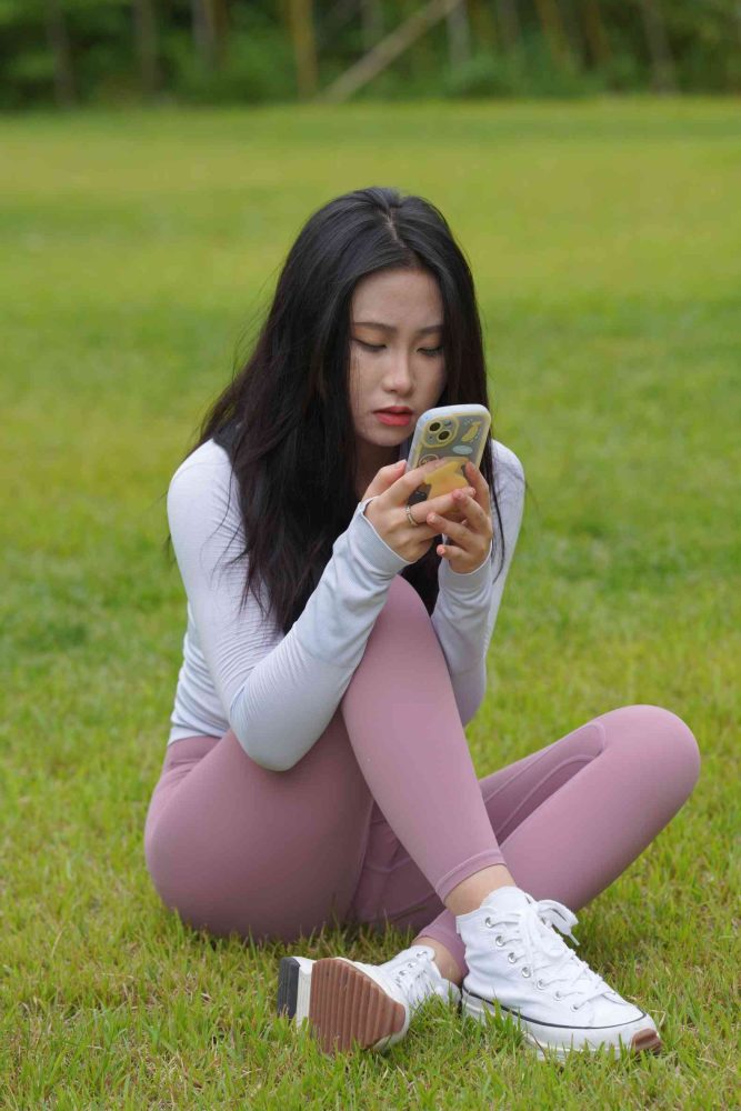 图片[1]-坐在草地玩手机的瑜伽姑娘【733P】04012-爱拍图库